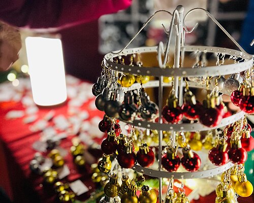 Selbstgebastelte Ohrringe im Weihnachtsdesign hängend an einem Tischständer